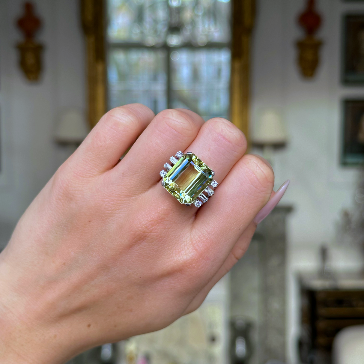 Vintage green heliodor and diamond ring worn on closed hand.