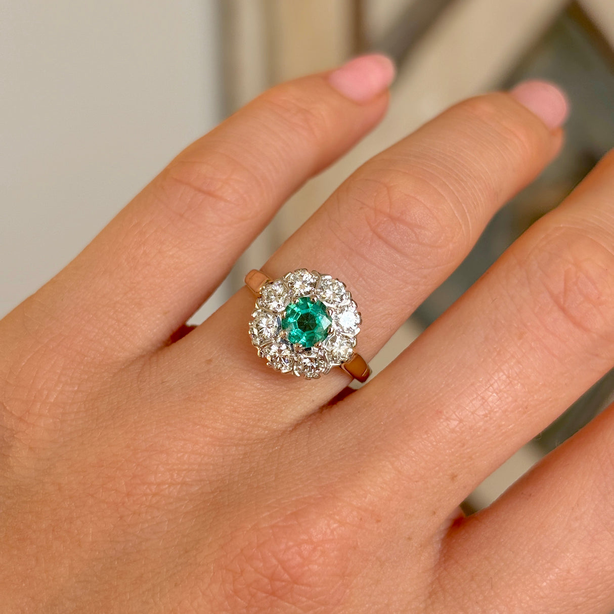 Vintage, 1980s emerald & diamond cluster ring on hand.