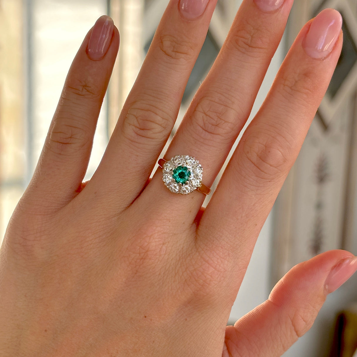 Vintage, 1980s emerald & diamond cluster ring worn on hand.