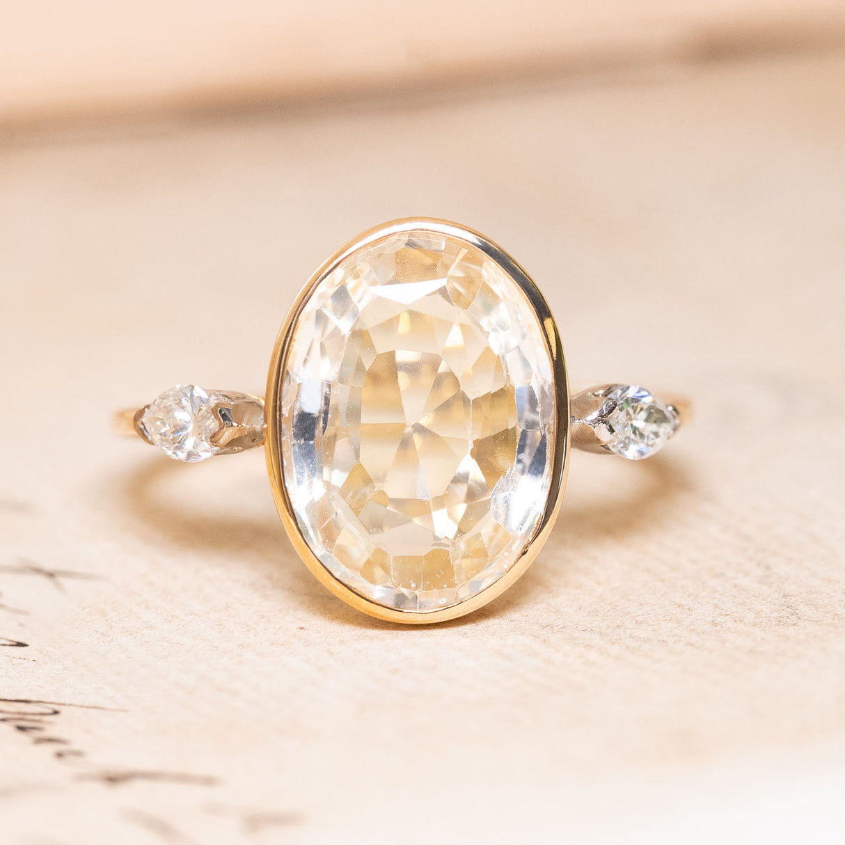 A yellow and white gold vintage ring with a large yellow sapphire flanked by two marquise diamonds.