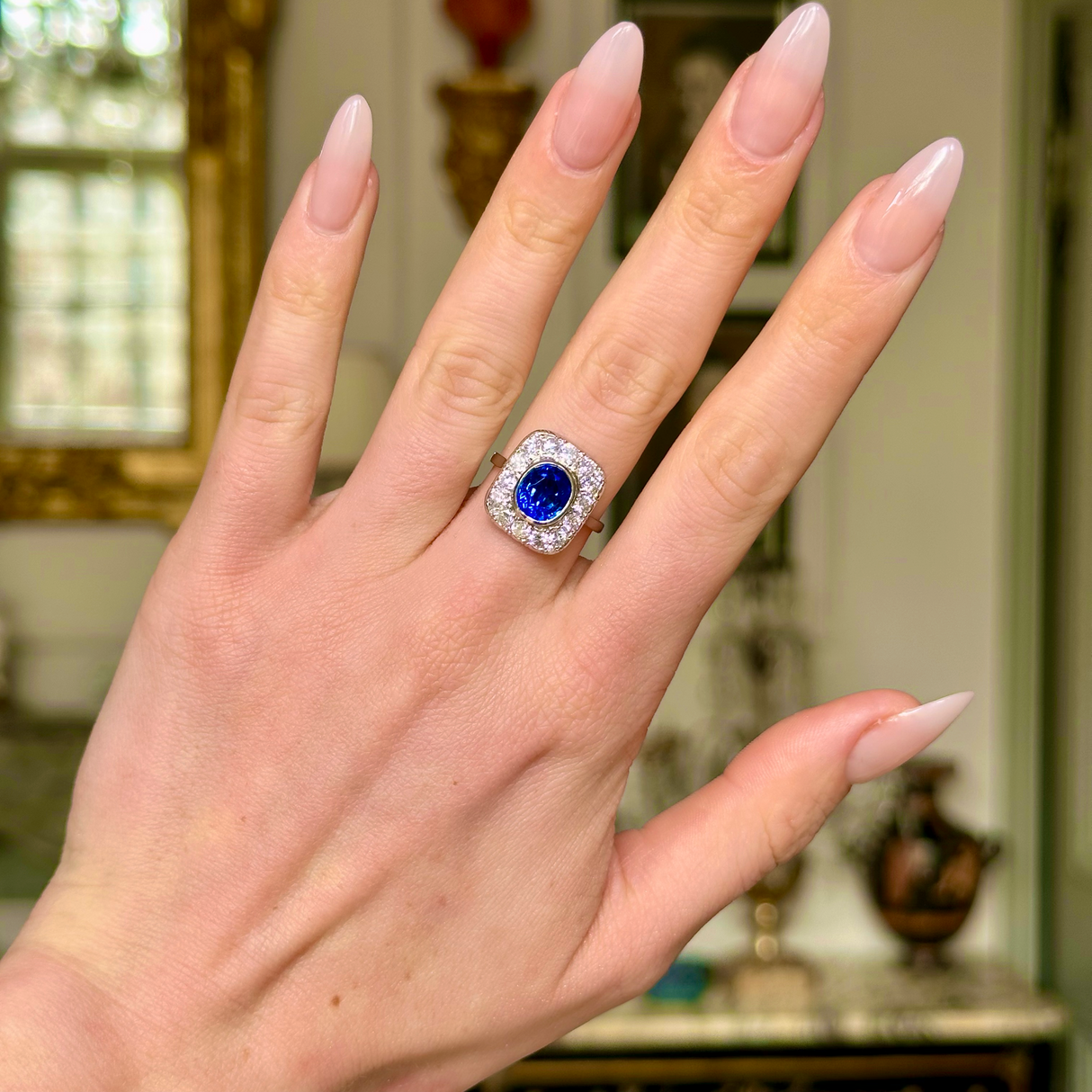 Art Deco sapphire and diamond cluster ring, worn on hand.