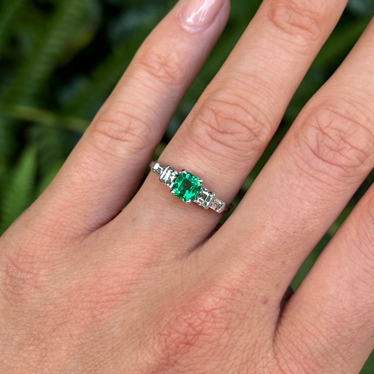 Vintage, Art Deco emerald & diamond five-stone ring worn on hand.