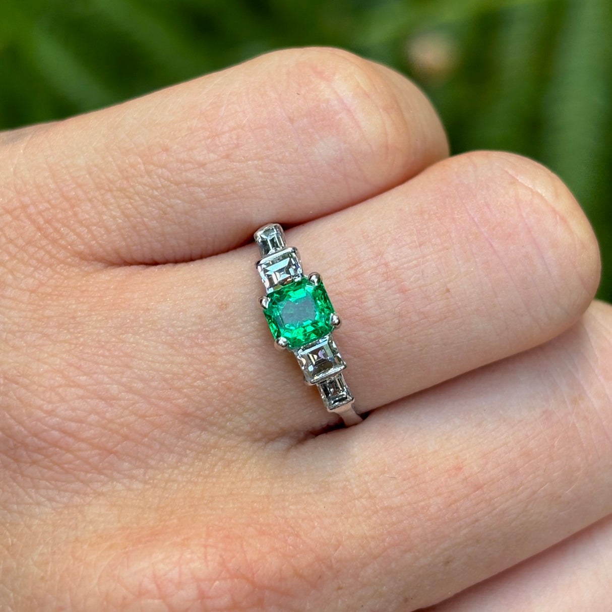 Vintage, Art Deco emerald & diamond five-stone ring worn on hand.
