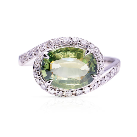 Green sapphire and diamond ring, front perspective on a white background.