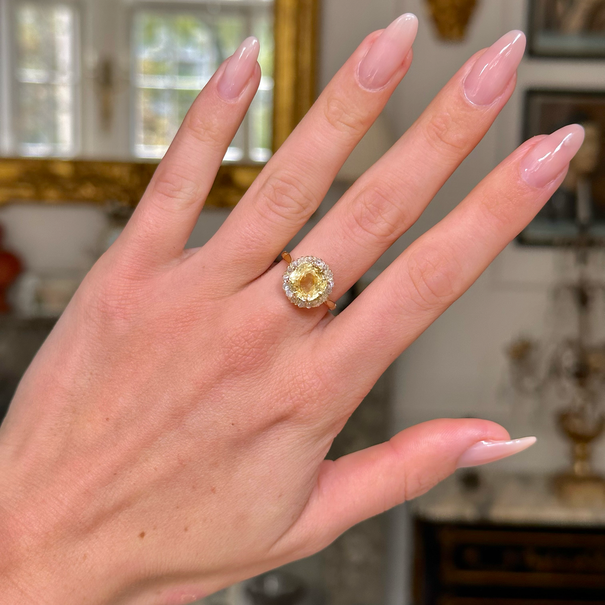 Vintage, Cushion-cut Yellow Sapphire Diamond Cluster Engagement Ring, worn on hand, front view.