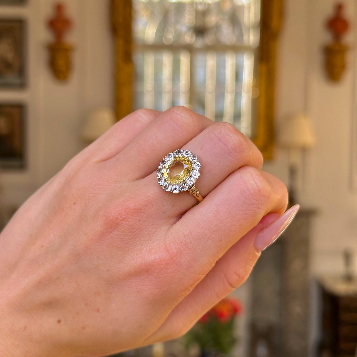 yellow sapphire and diamond cluster ring worn on closed hand.