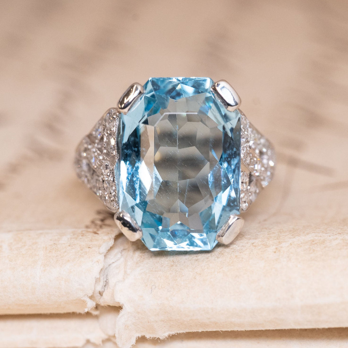 Antique Art Deco aquamarine and diamond cocktail ring featuring a large emerald-cut aquamarine with diamond-set shoulders in platinum.