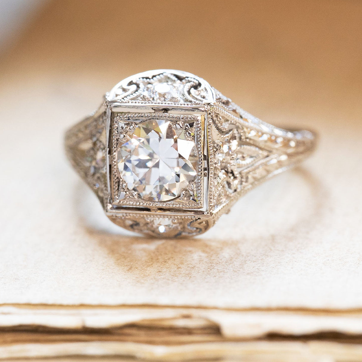 Antique Art Deco diamond cluster ring with old-cut diamond and intricate filigree detailing.