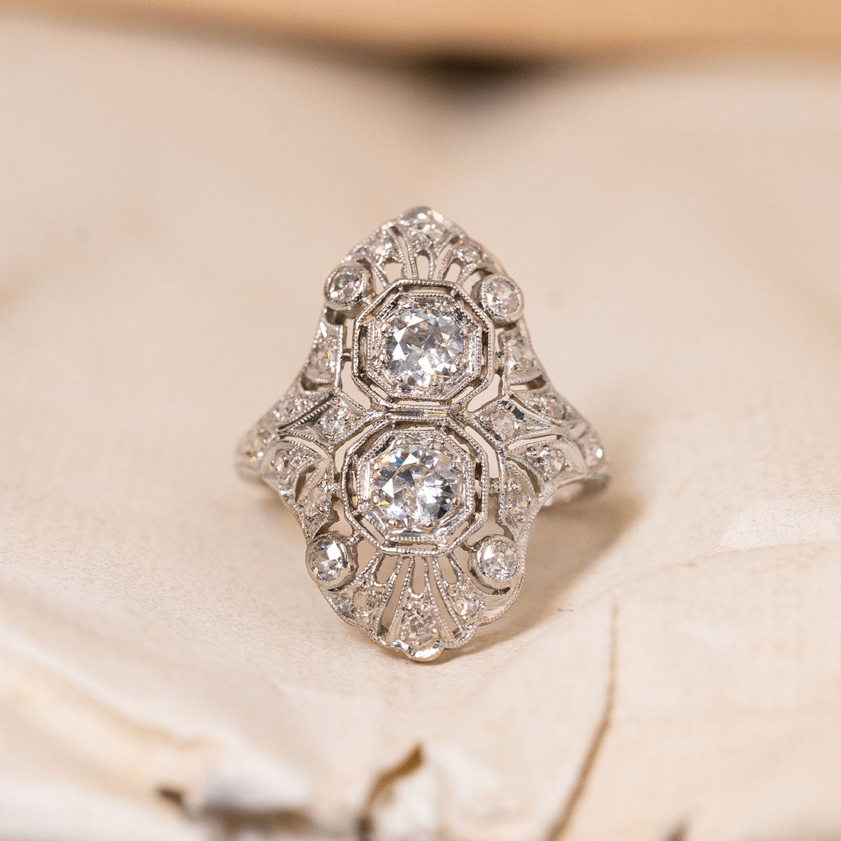 Antique Art Deco filigree diamond cluster ring featuring old-cut diamonds within an intricate openwork plaque design.