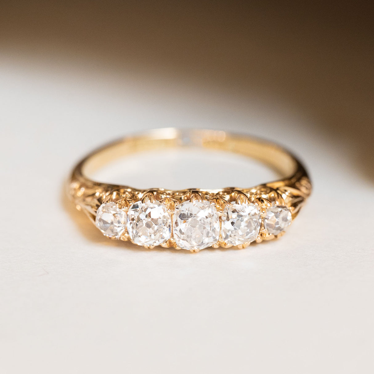 Antique five-stone diamond ring with old-mine cut diamonds, decorative Victorian goldwork and a timeless handcrafted design.