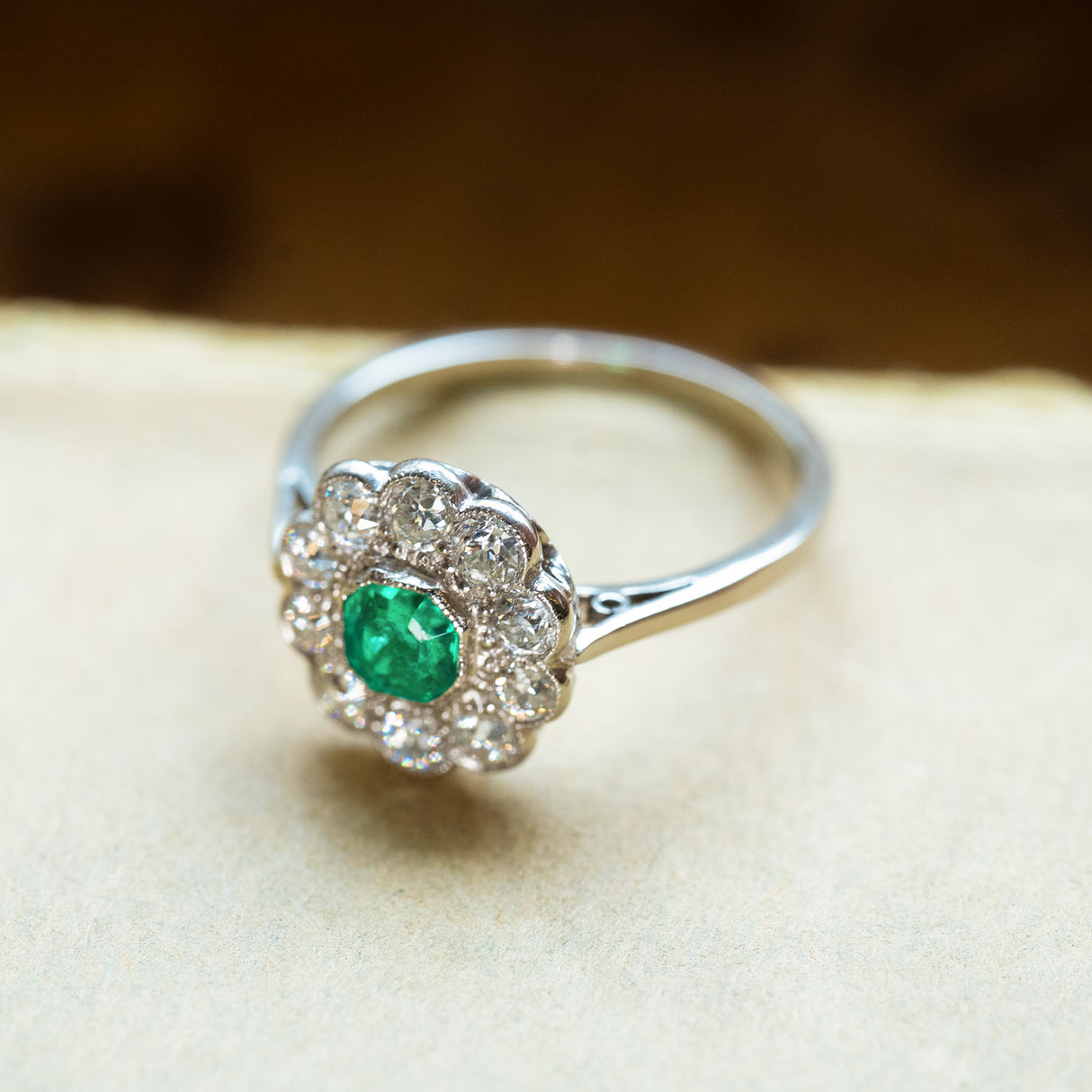 Antique Edwardian emerald and old-mine cut diamond cluster ring with delicate antique-inspired cluster setting.