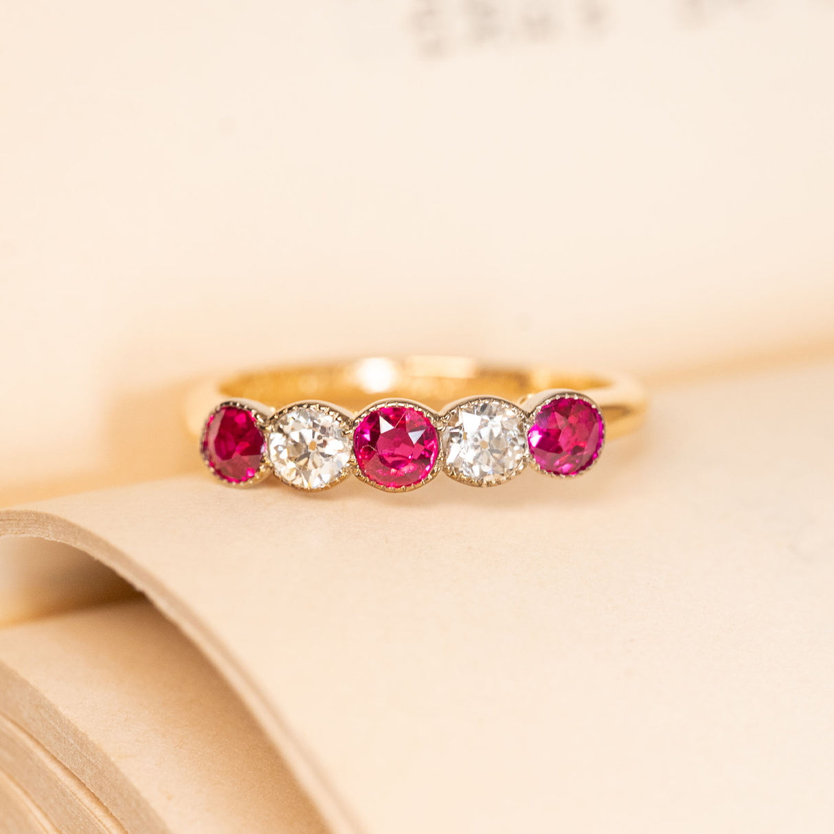 Antique Edwardian five-stone ring featuring vibrant rubies alternating with sparkling old-cut diamonds in a classic yellow gold setting.