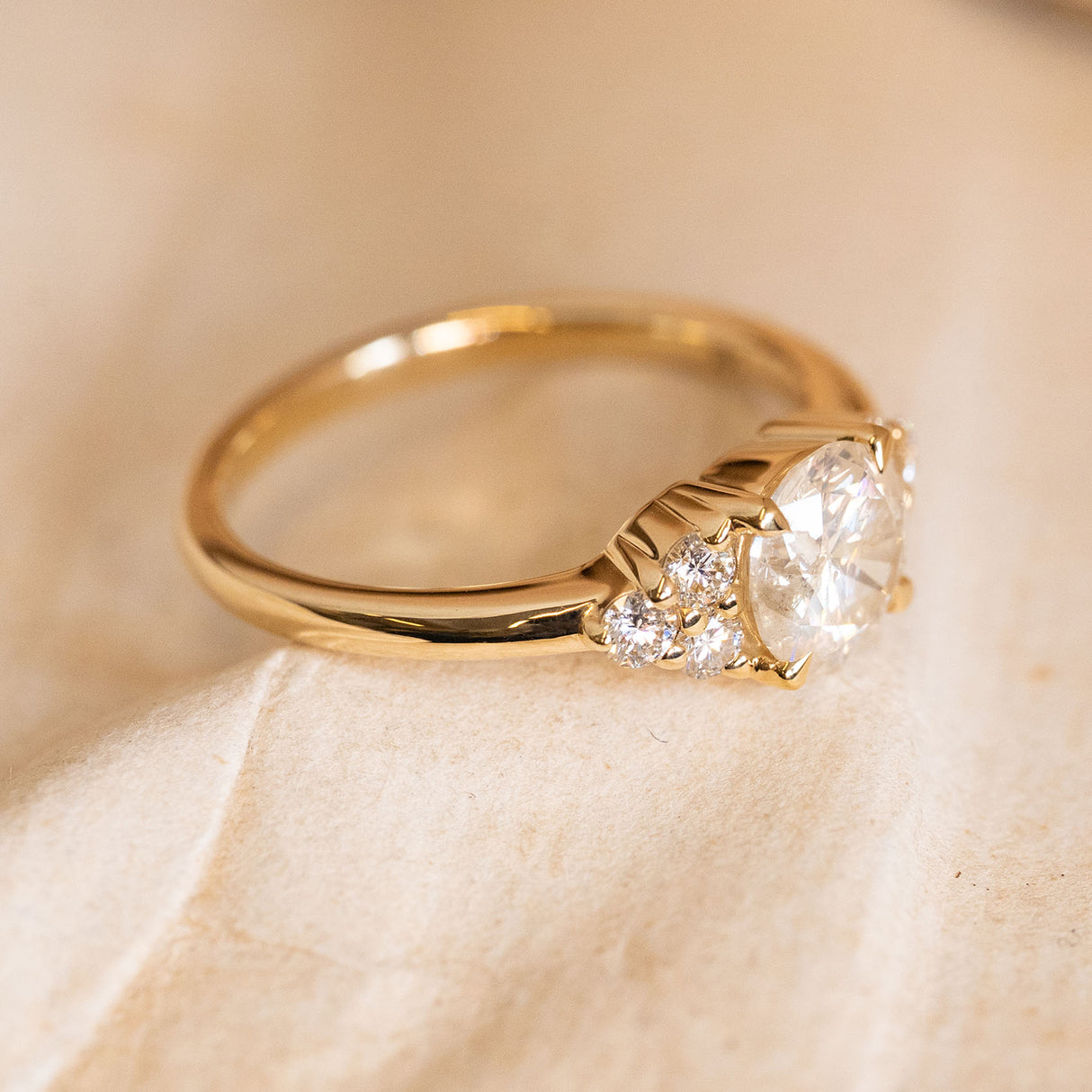 Antique inspired diamond trefoil cluster engagement ring displaying the raised setting and trefoil diamond cluster design in yellow gold.