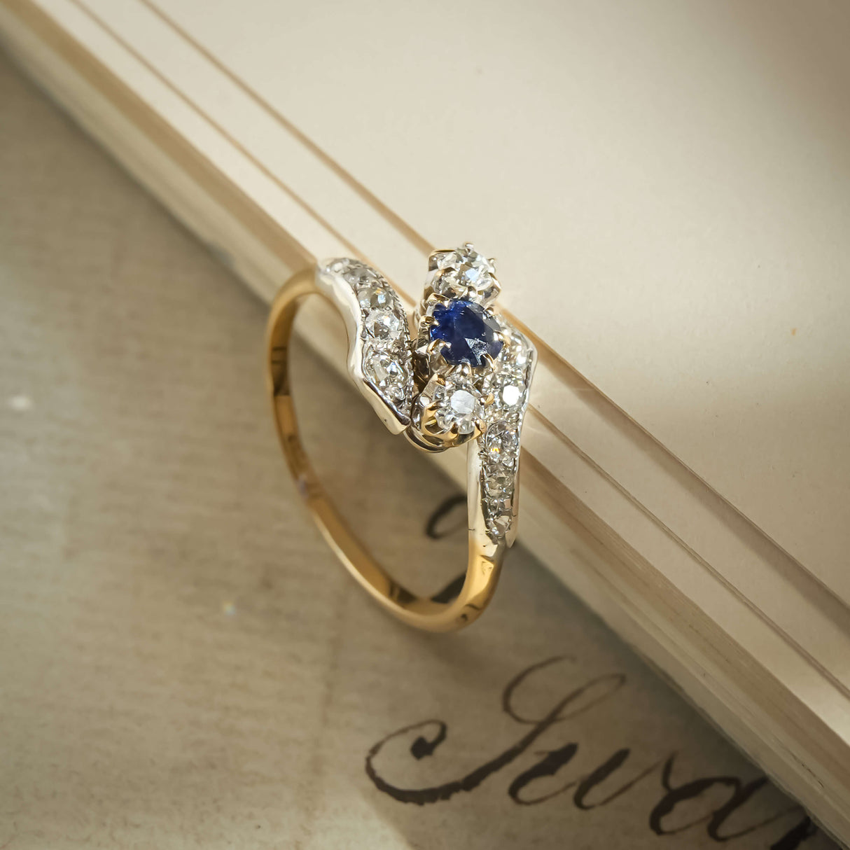Antique Edwardian sapphire and diamond twist ring with blue gemstone in gold setting