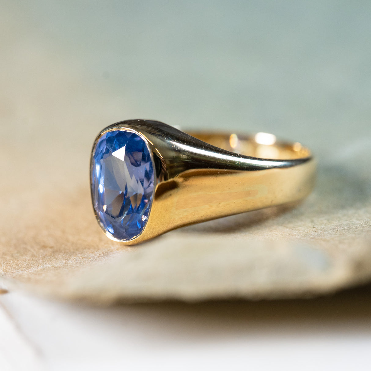 Antique Victorian sapphire single-stone ring with bezel-set blue sapphire and smooth gold band.