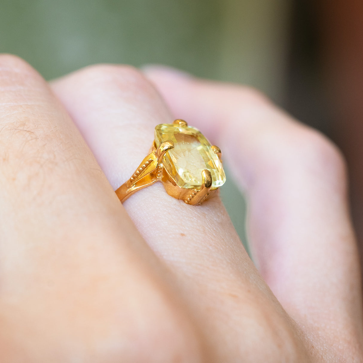Detailed view of antique Victorian yellow sapphire solitaire ring showing ornate gold setting.