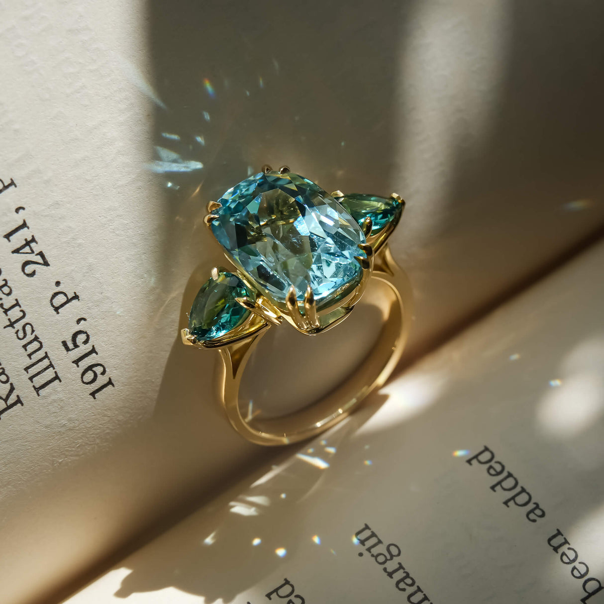 Aquamarine and sea green tourmaline ring with three stone design in gold