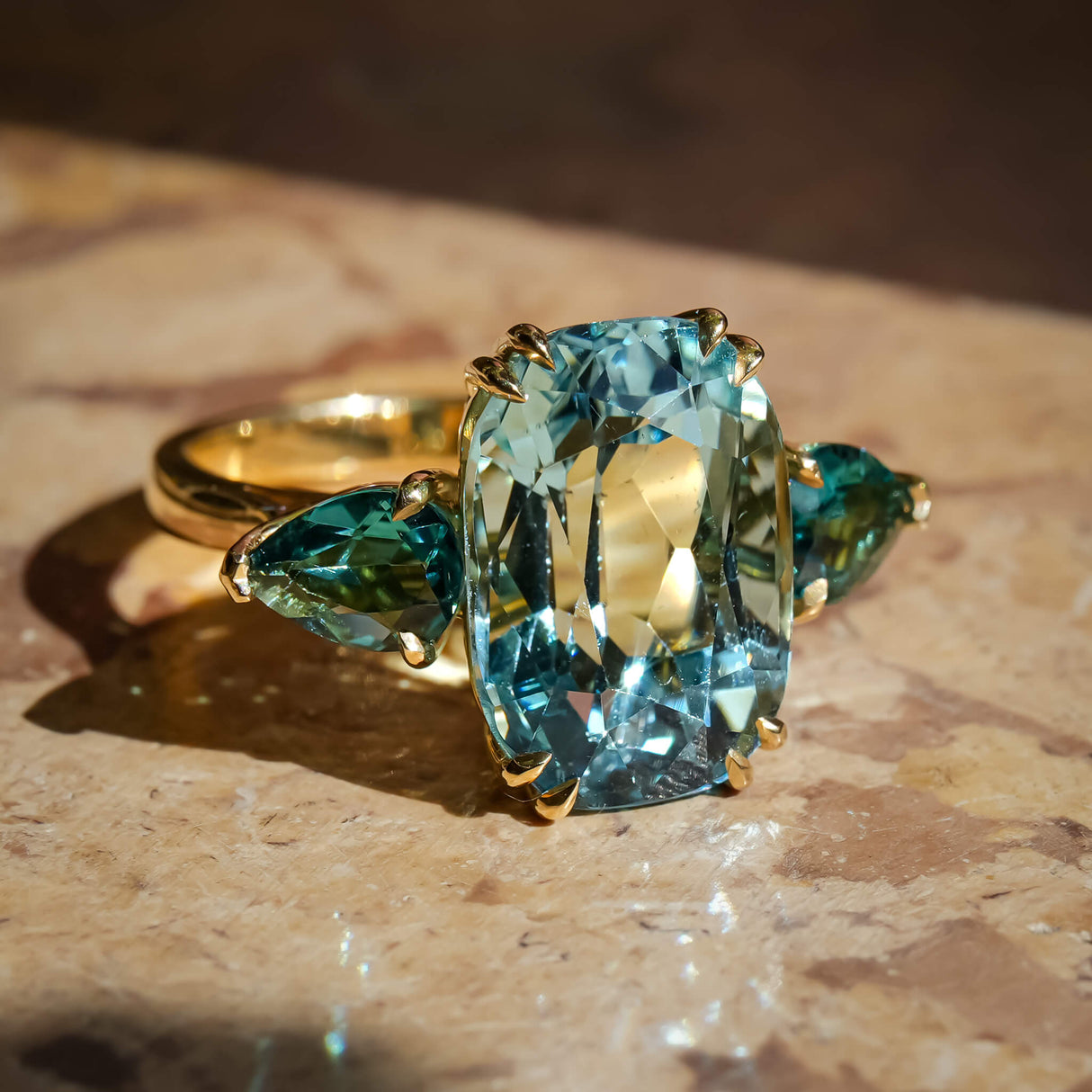 Aquamarine center stone with sea green tourmaline side stones cocktail ring