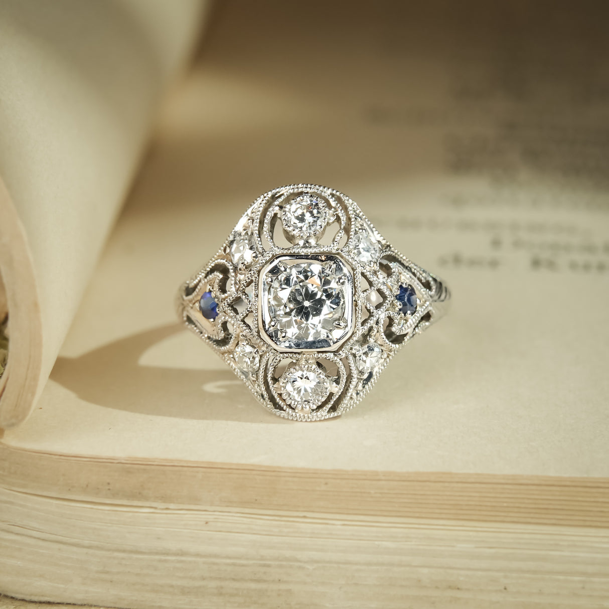 Art Deco diamond cluster ring with sapphire accents in antique design