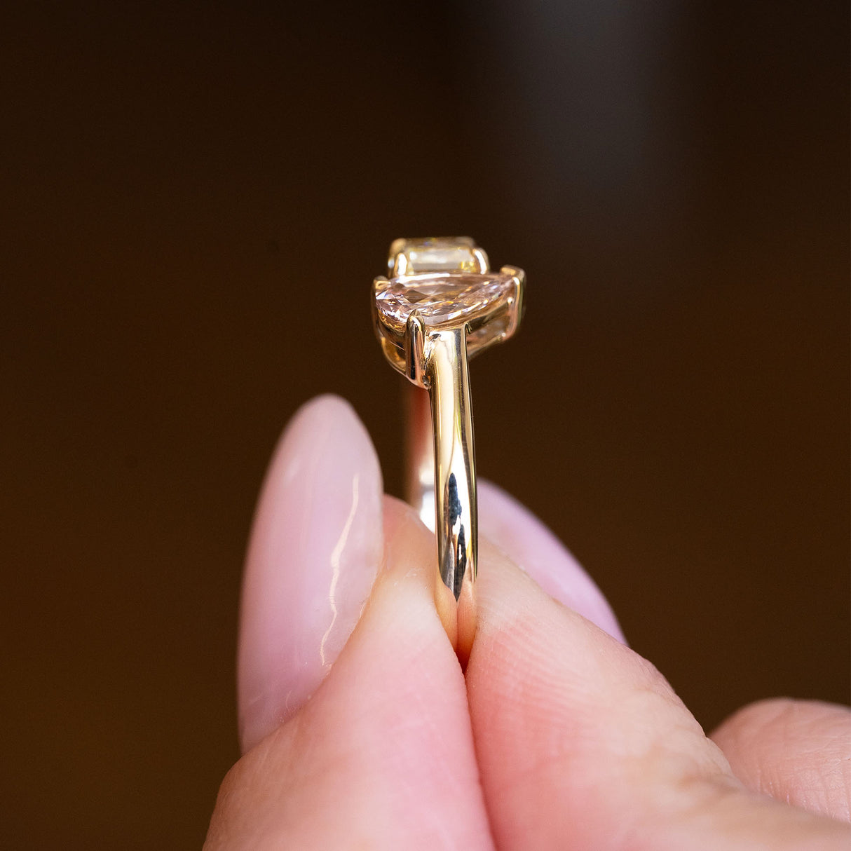 Brown and yellow diamond Toi et Moi engagement ring showing slim gold band and raised setting.