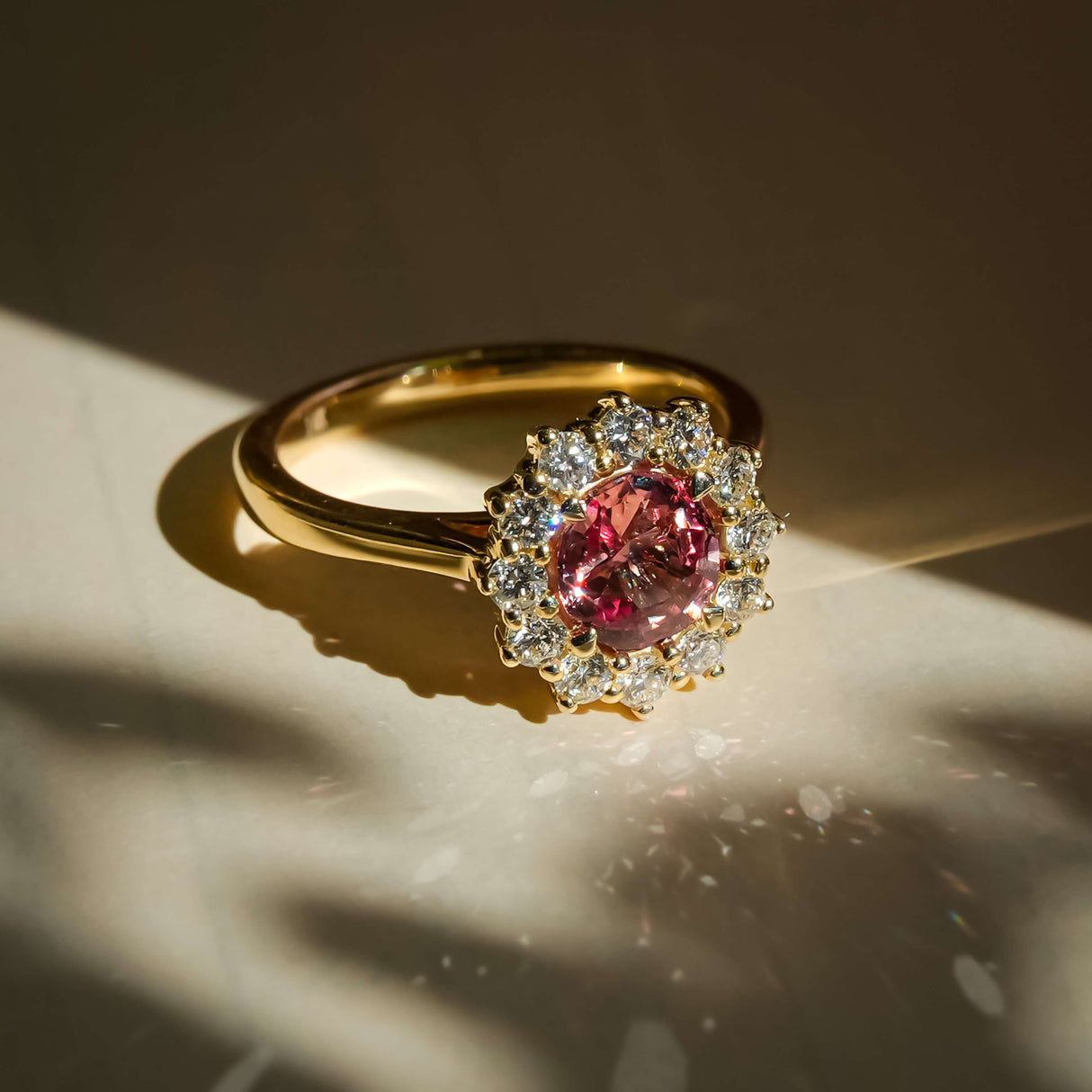 burnt orange sapphire cluster engagement ring with diamond halo in yellow gold