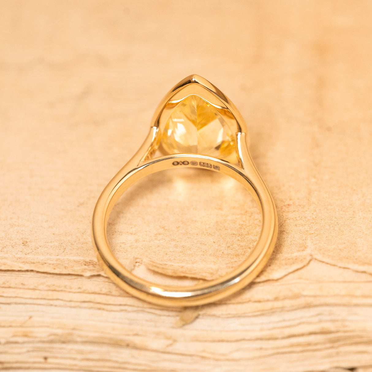 Yellow gold solitaire ring showcasing a canary yellow pear-cut sapphire with clean, contemporary styling.