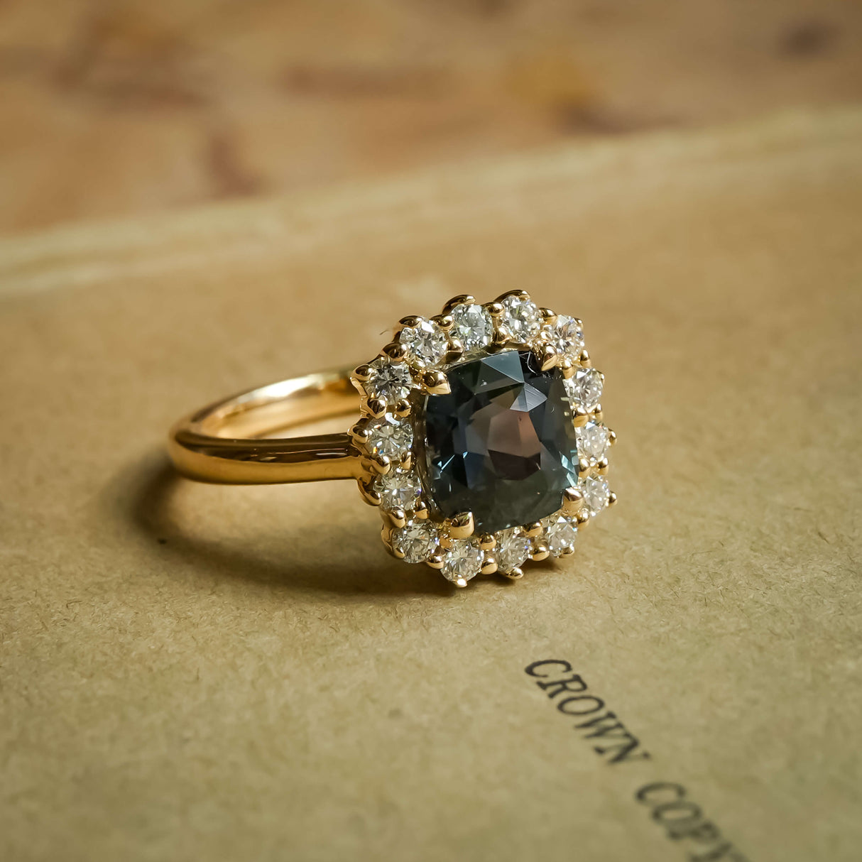 Cushion cut green sapphire and diamond cluster engagement ring in yellow gold band