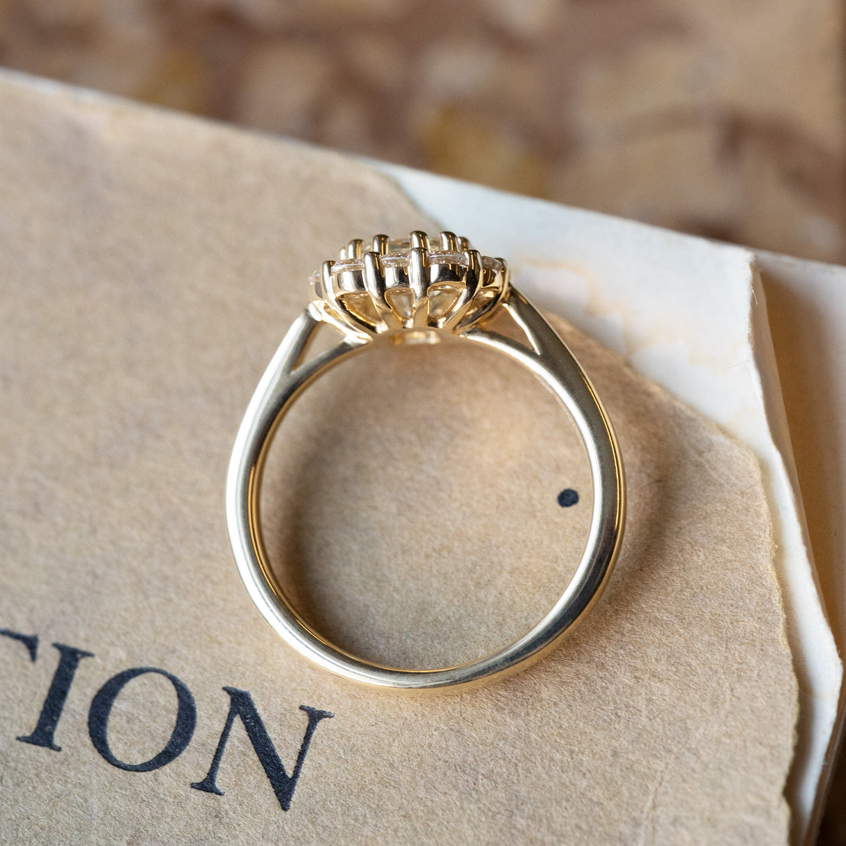 Diamond cluster engagement ring with elevated diamond setting and open gallery detail.