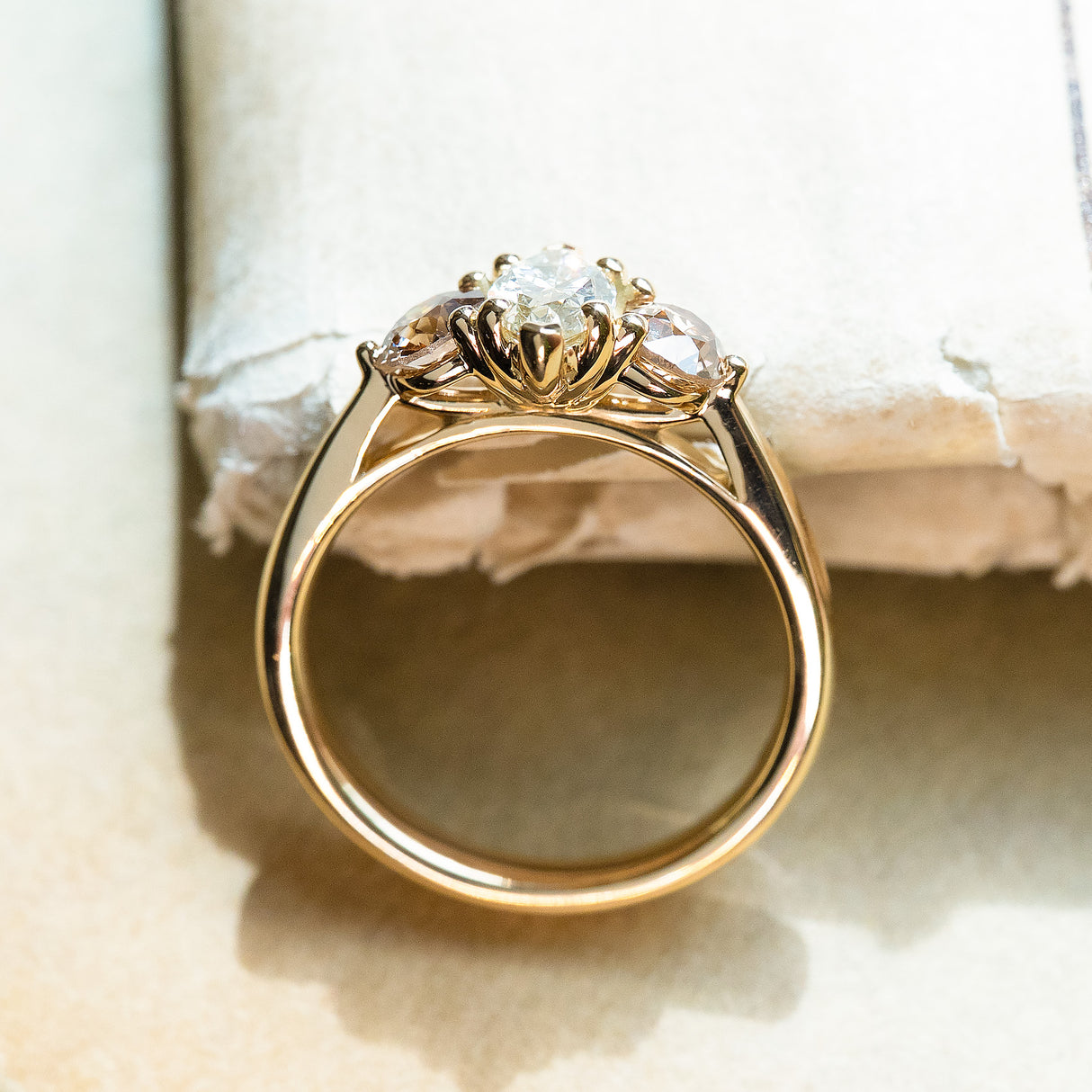 Diamond three-stone engagement ring with elevated marquise-cut centre stone and sculpted gallery detail.