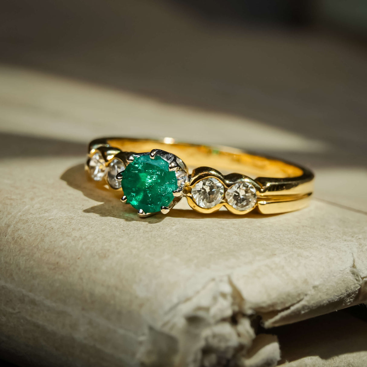 1990s vintage emerald and diamond five stone ring with central green emerald and diamonds