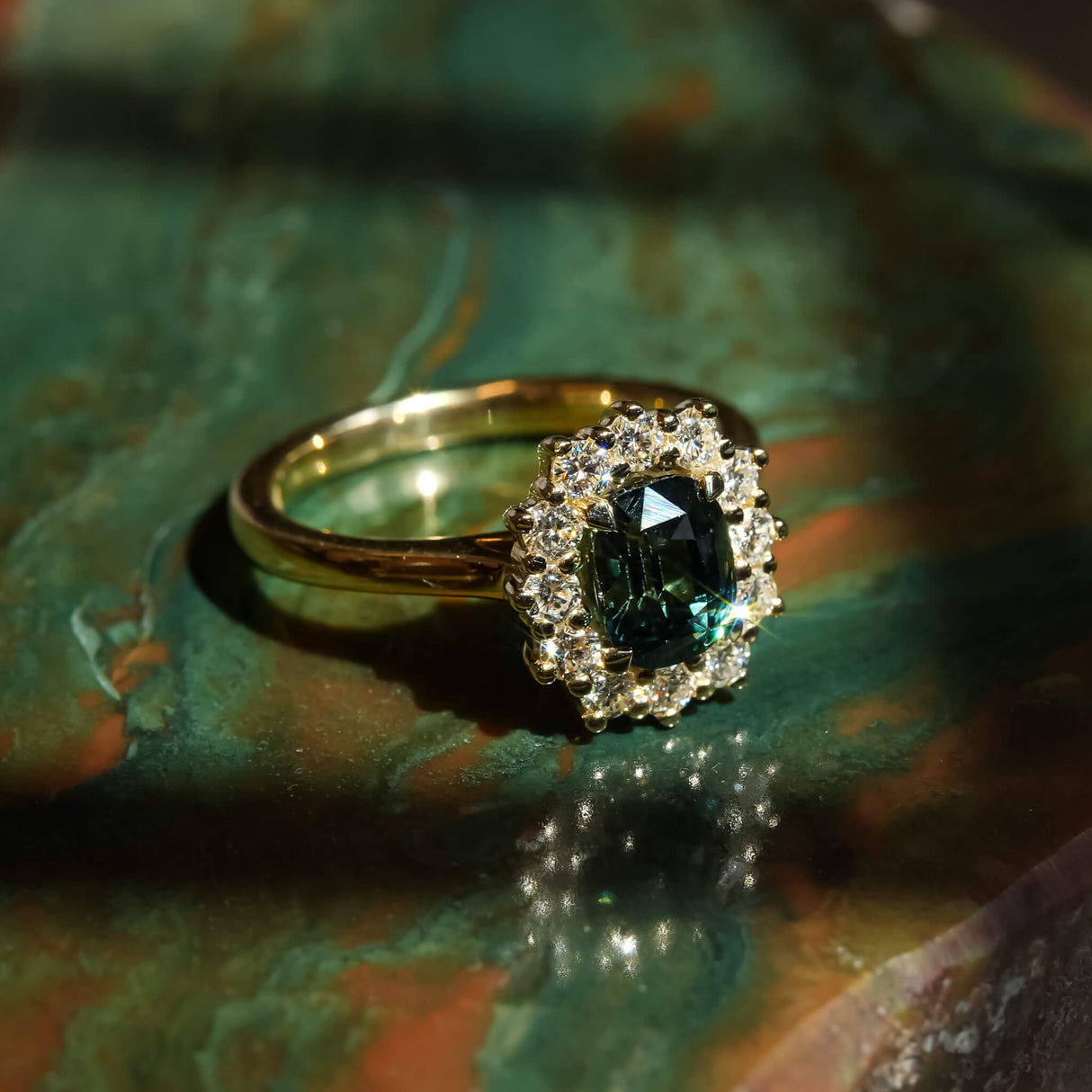 Green sapphire and diamond cluster engagement ring in yellow gold