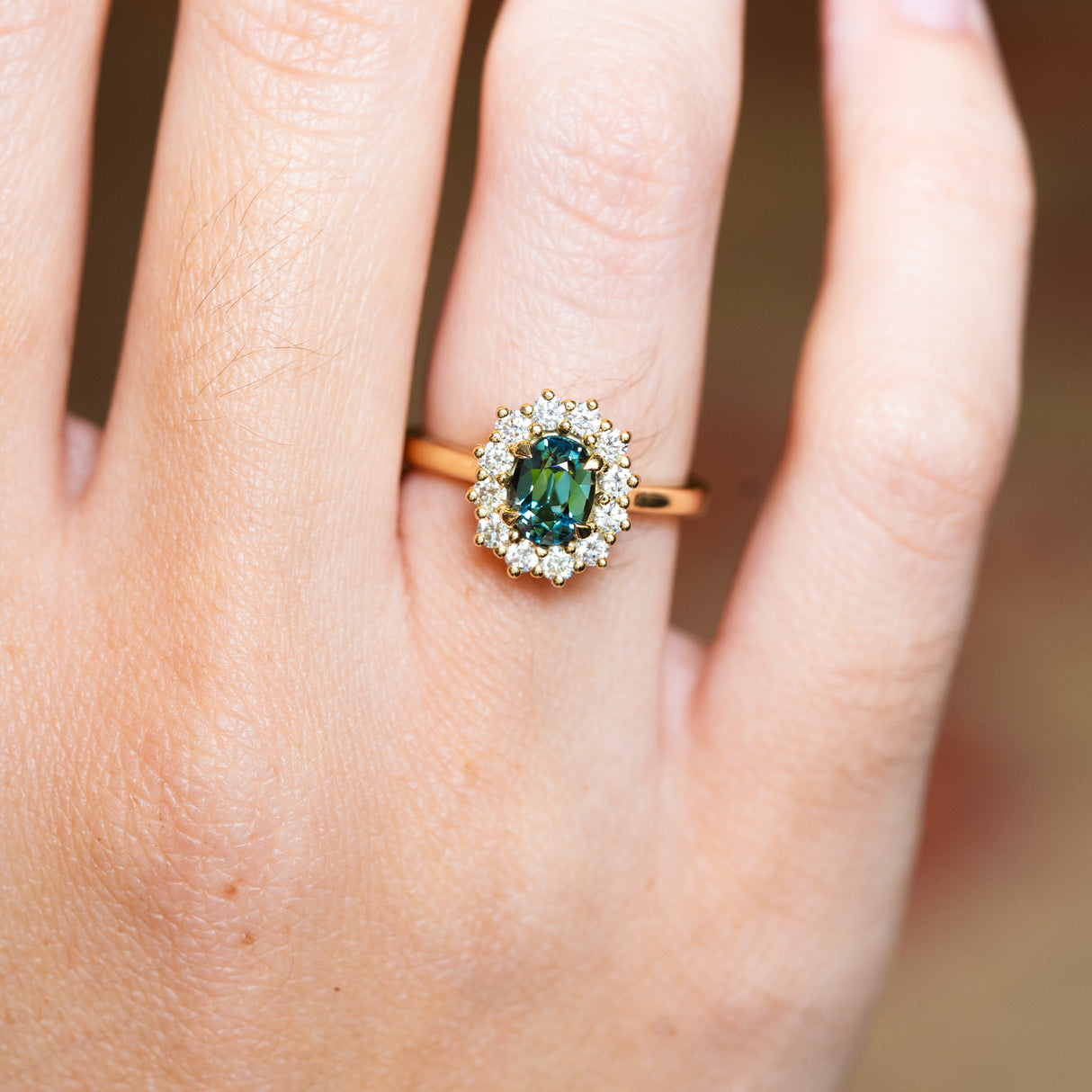 Sapphire and diamond cluster ring highlighting central stone and surrounding diamonds.