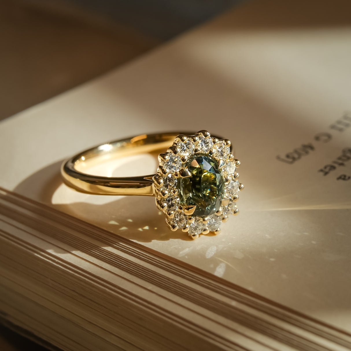 Green sapphire engagement ring with oval gemstone and diamond cluster halo