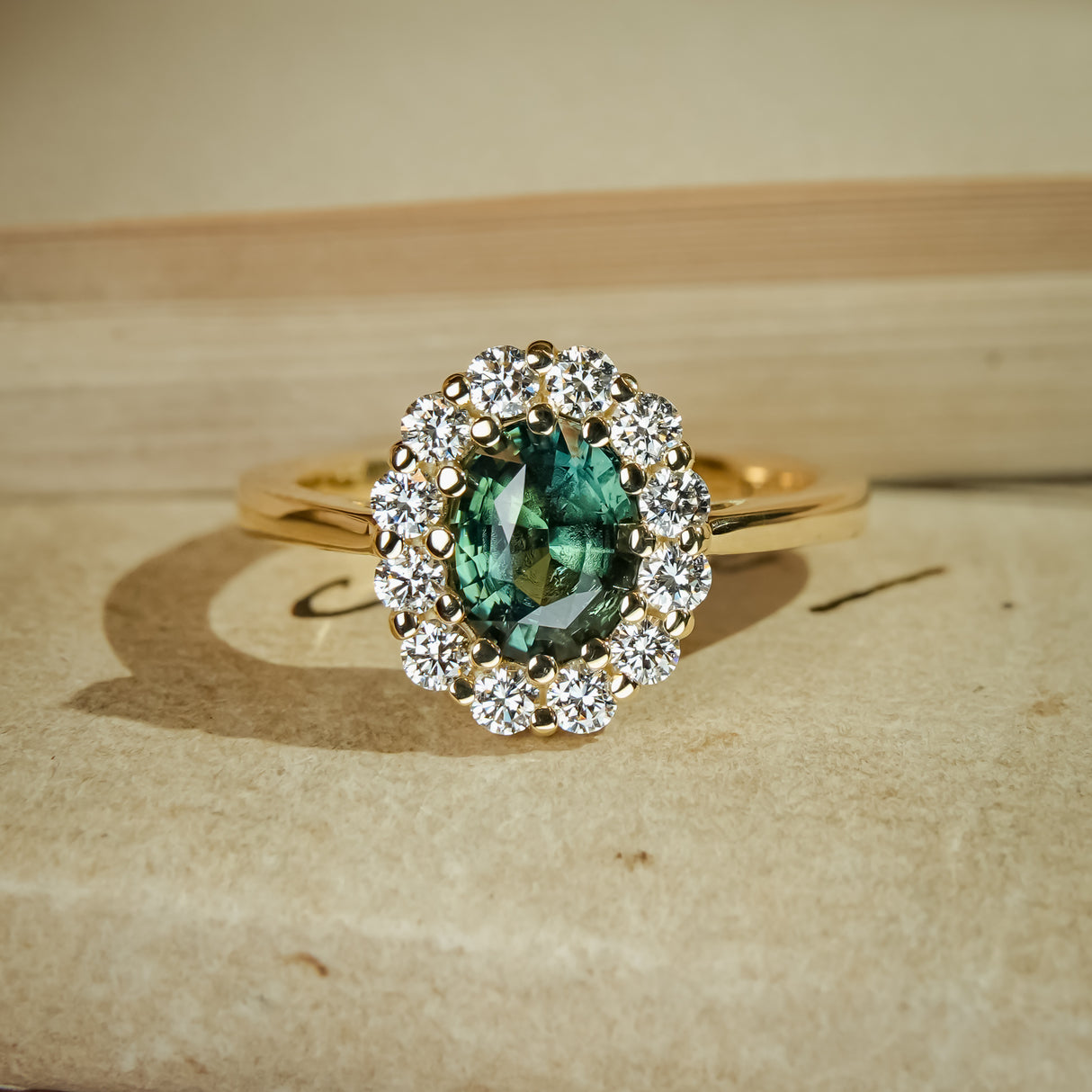 Oval green sapphire halo diamond engagement ring in yellow gold