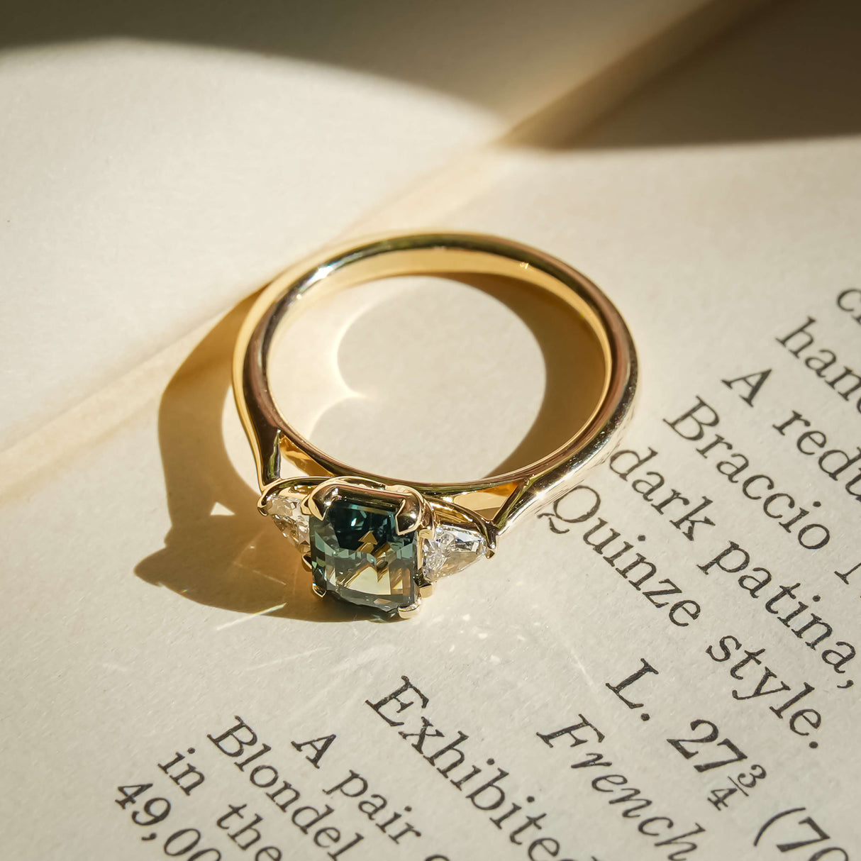 Green sapphire center stone with trillion diamonds three stone engagement ring