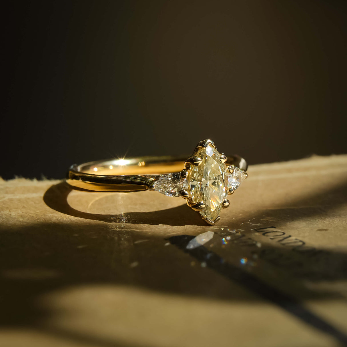 Marquise cut diamond three stone engagement ring in yellow gold band