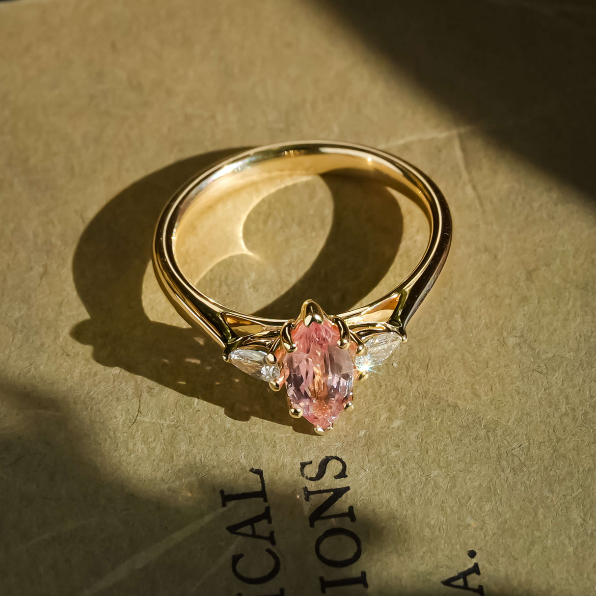 marquise cut pink sapphire diamond three stone engagement ring with yellow gold band