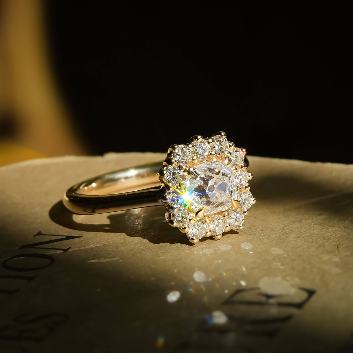 old mine cut cushion diamond cluster ring with pavé halo in yellow gold