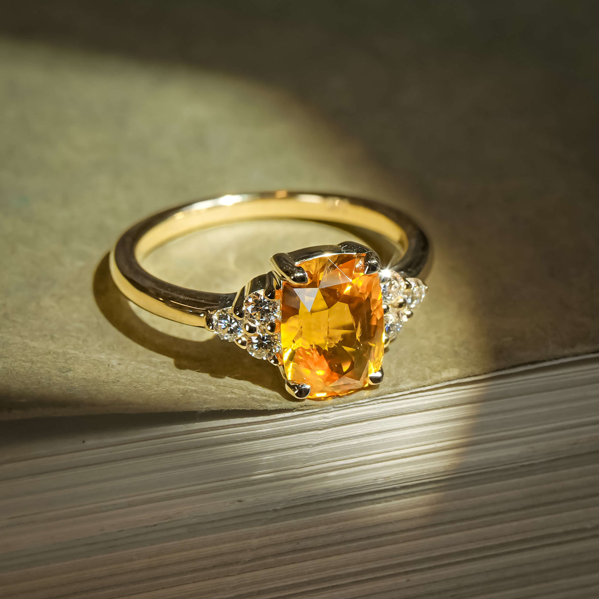 Orange cushion cut sapphire ring with diamond cluster trefoil design
