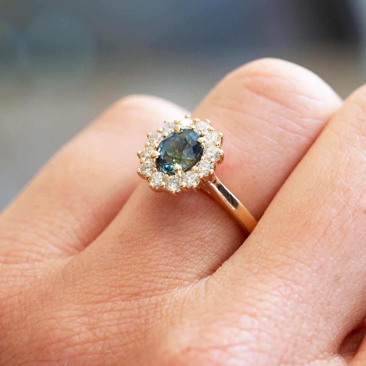 Sapphire and diamond cluster ring highlighting oval cut centre stone and surrounding diamonds.