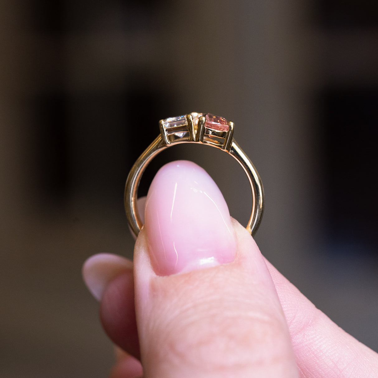 Peach coloured sapphire and diamond Toi et Moi engagement ring showing open gallery setting and gold band.