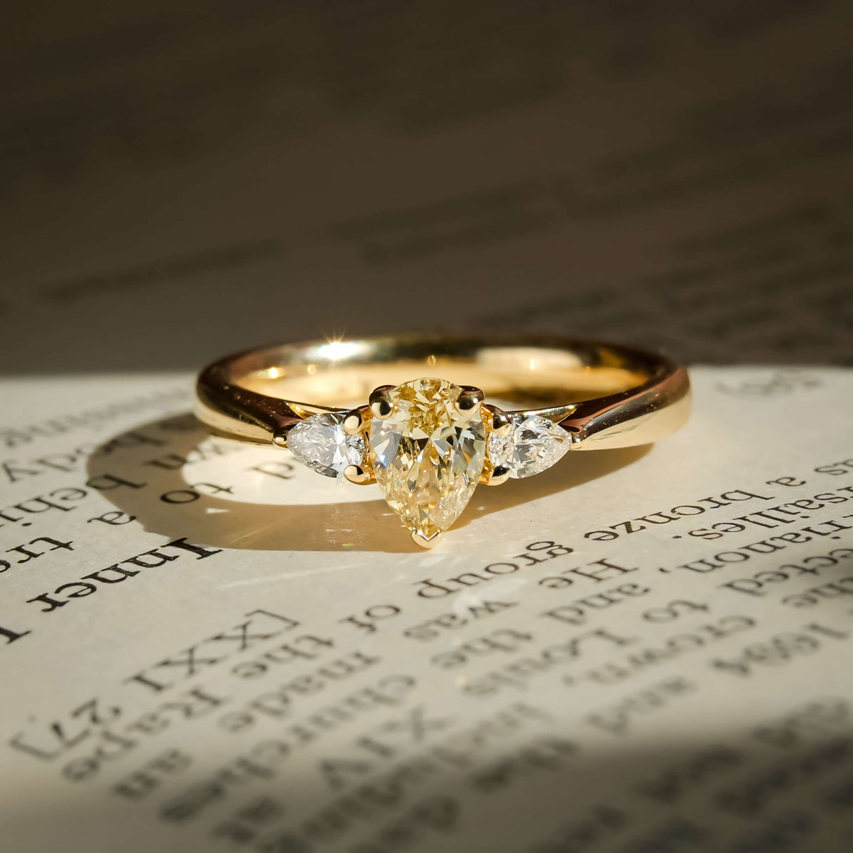 pear shaped yellow diamond three stone engagement ring with tapered side diamonds
