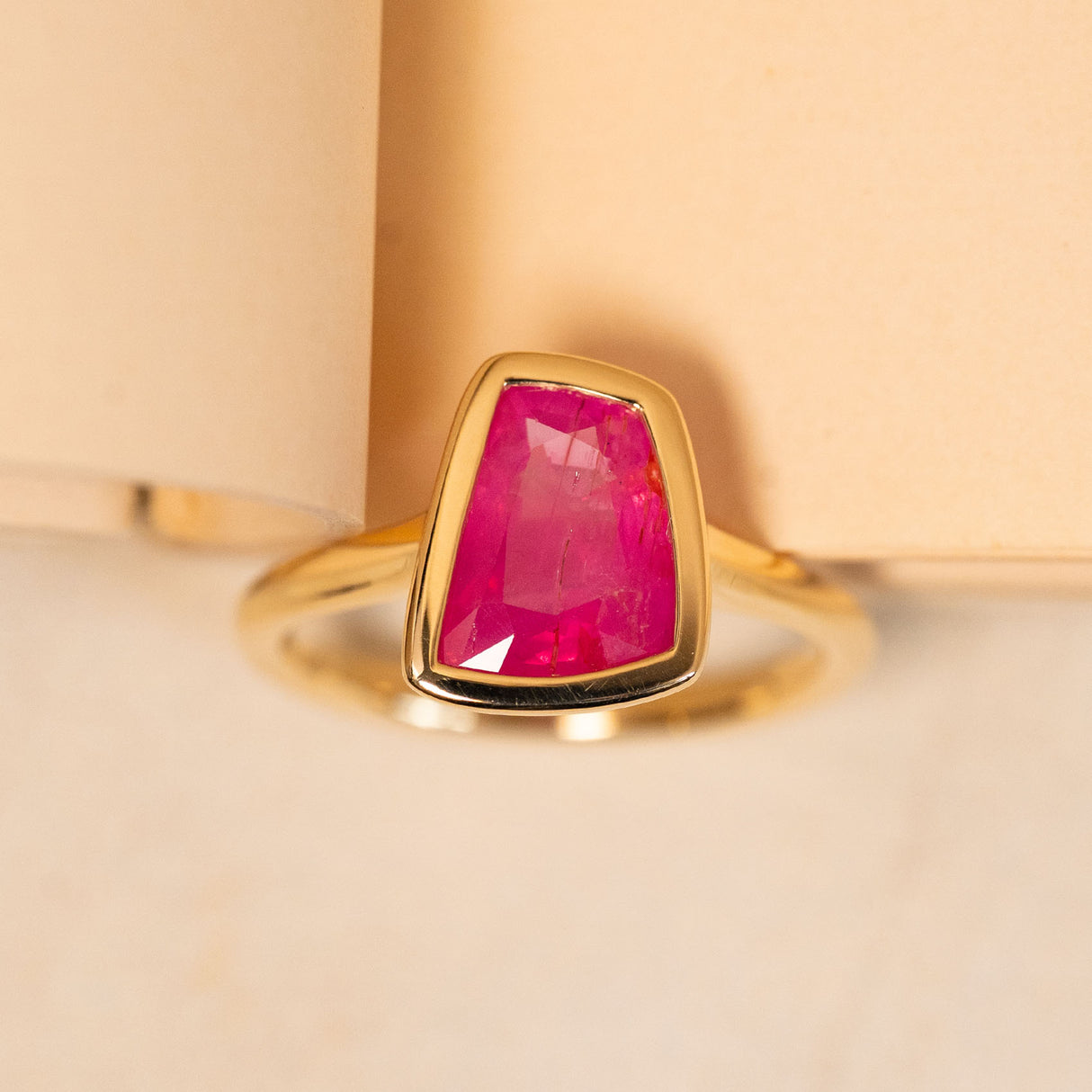 Pink ruby solitaire engagement ring featuring a vivid pink ruby in a sleek yellow gold design.