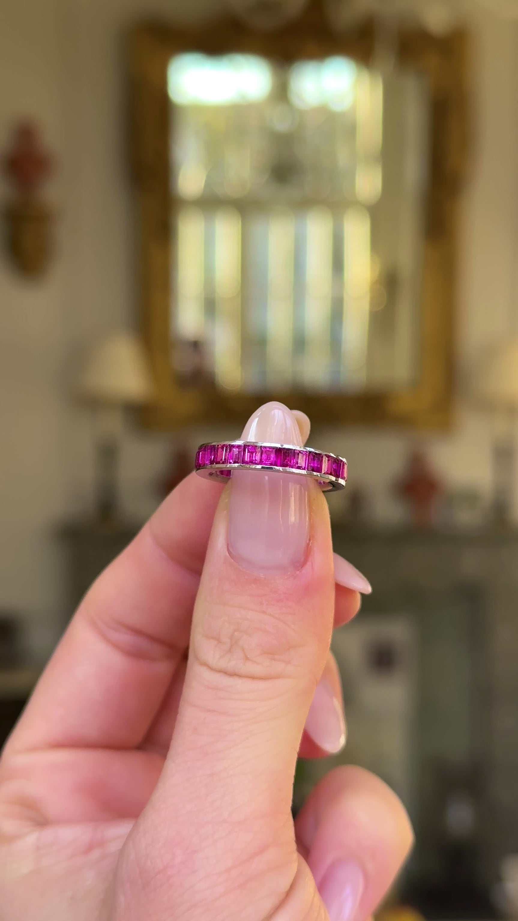 Vintage ruby eternity ring held in fingers and moved around to give perspective.