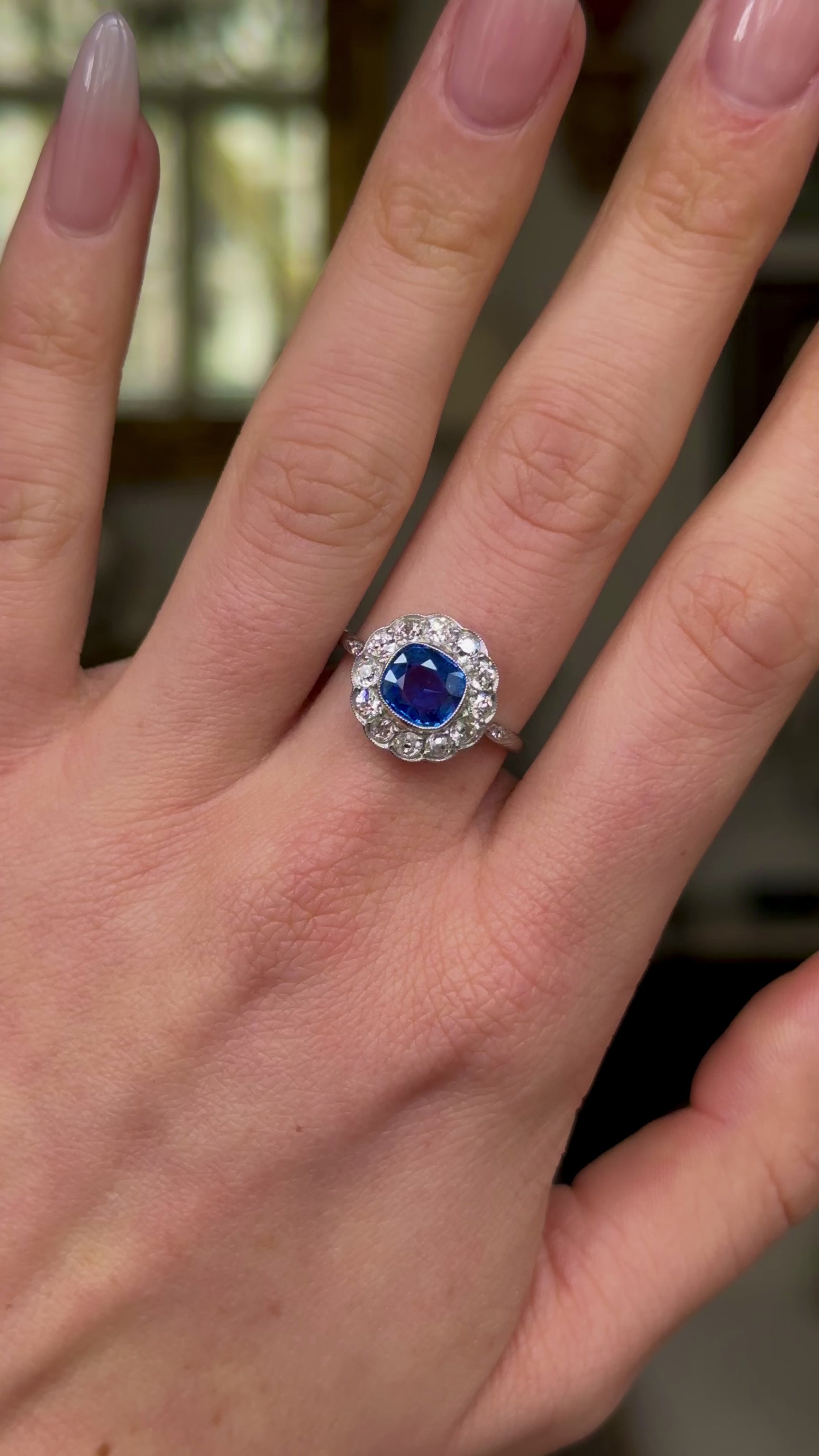 Vintage, 1940s Ceylon Cushion-Cut Sapphire and Diamond Cluster Engagement Ring, worn on hand and rotated to give perspective.