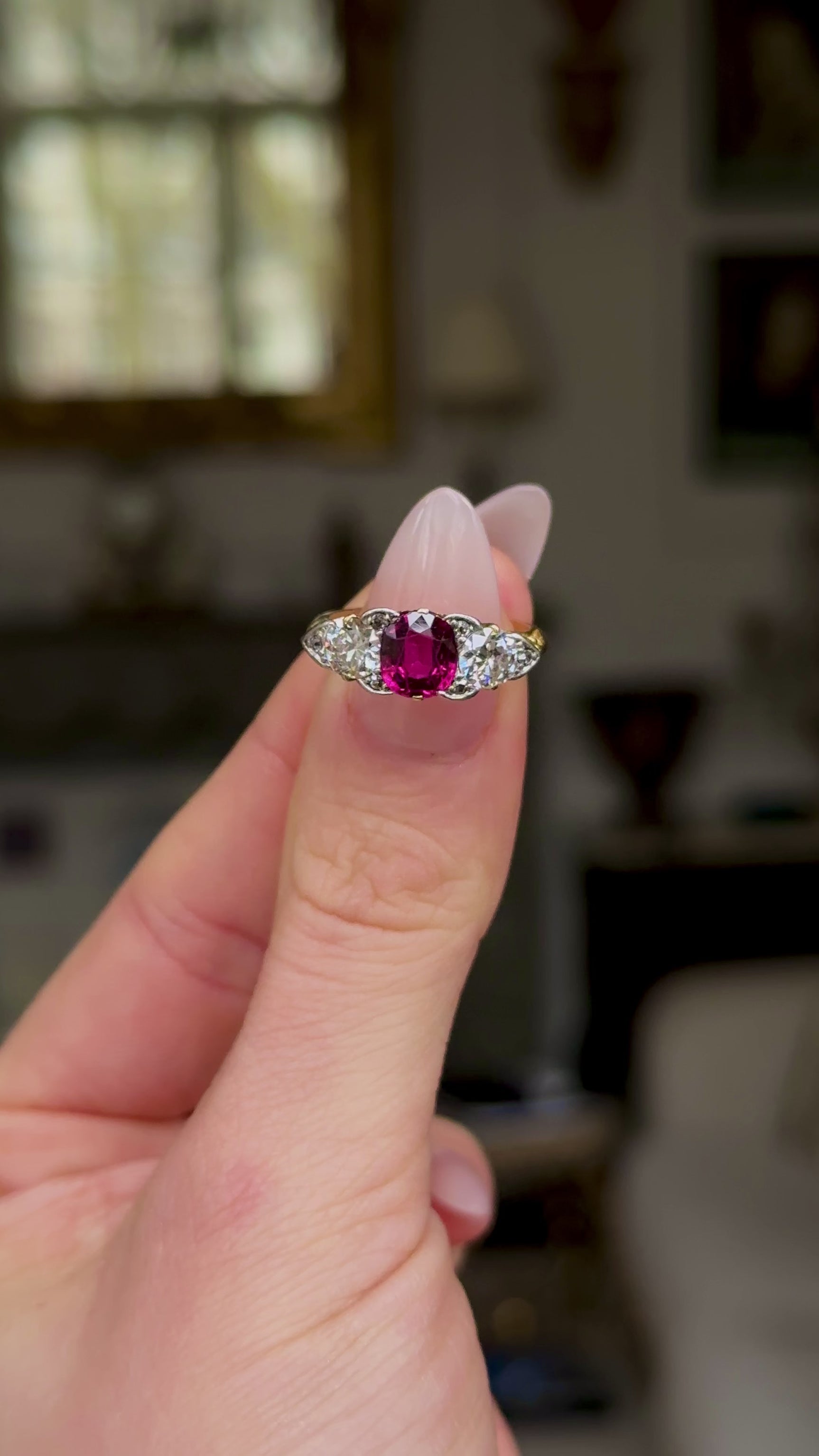 Antique, Edwardian Three Stone Ruby and Diamond Engagement Ring, held in fingers and rotated to give perspective.