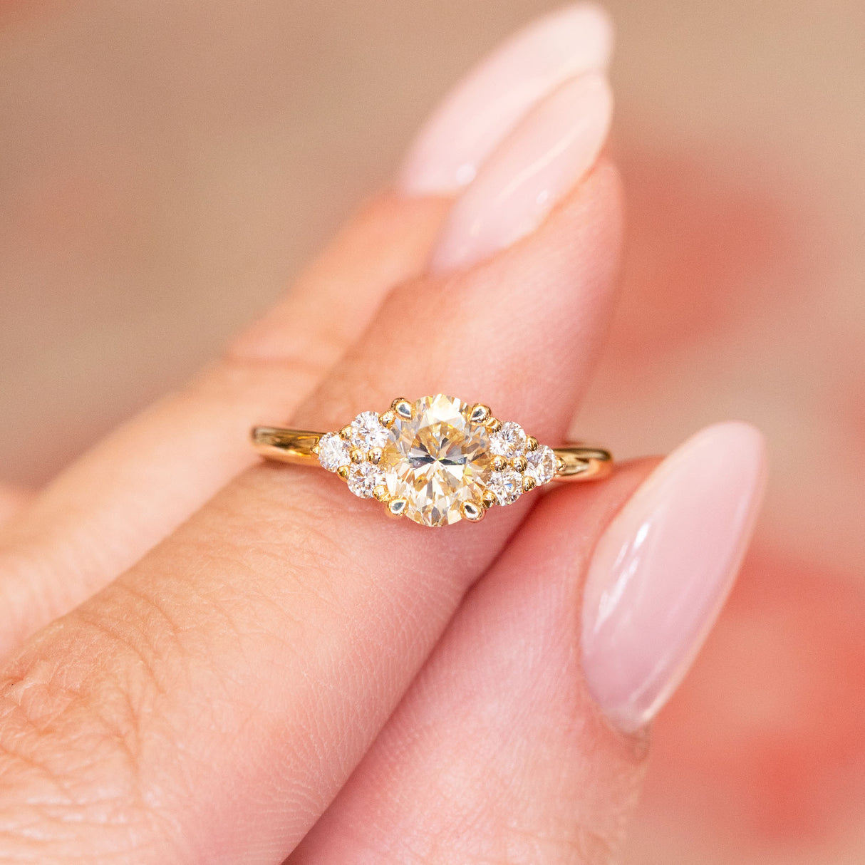 Antique-inspired primrose yellow diamond cluster tre-foil engagement ring with oval yellow diamond and surrounding diamond clusters.