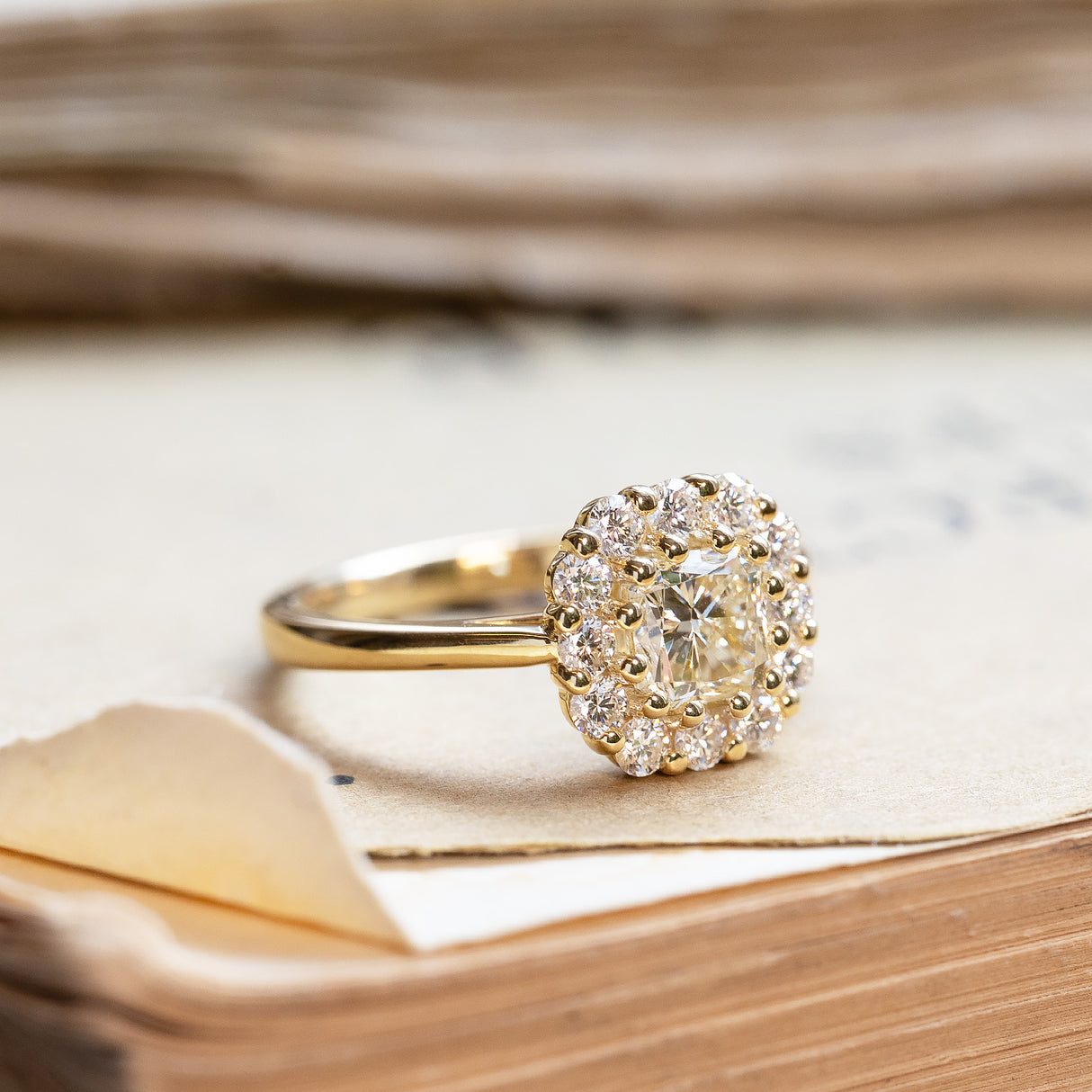 Diamond cluster engagement ring with yellow gold band and clustered diamond setting.