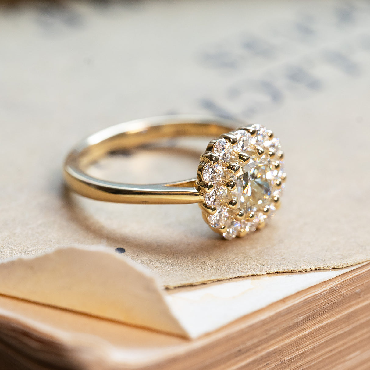 Diamond cluster engagement ring with brilliant-cut diamonds and yellow gold band.