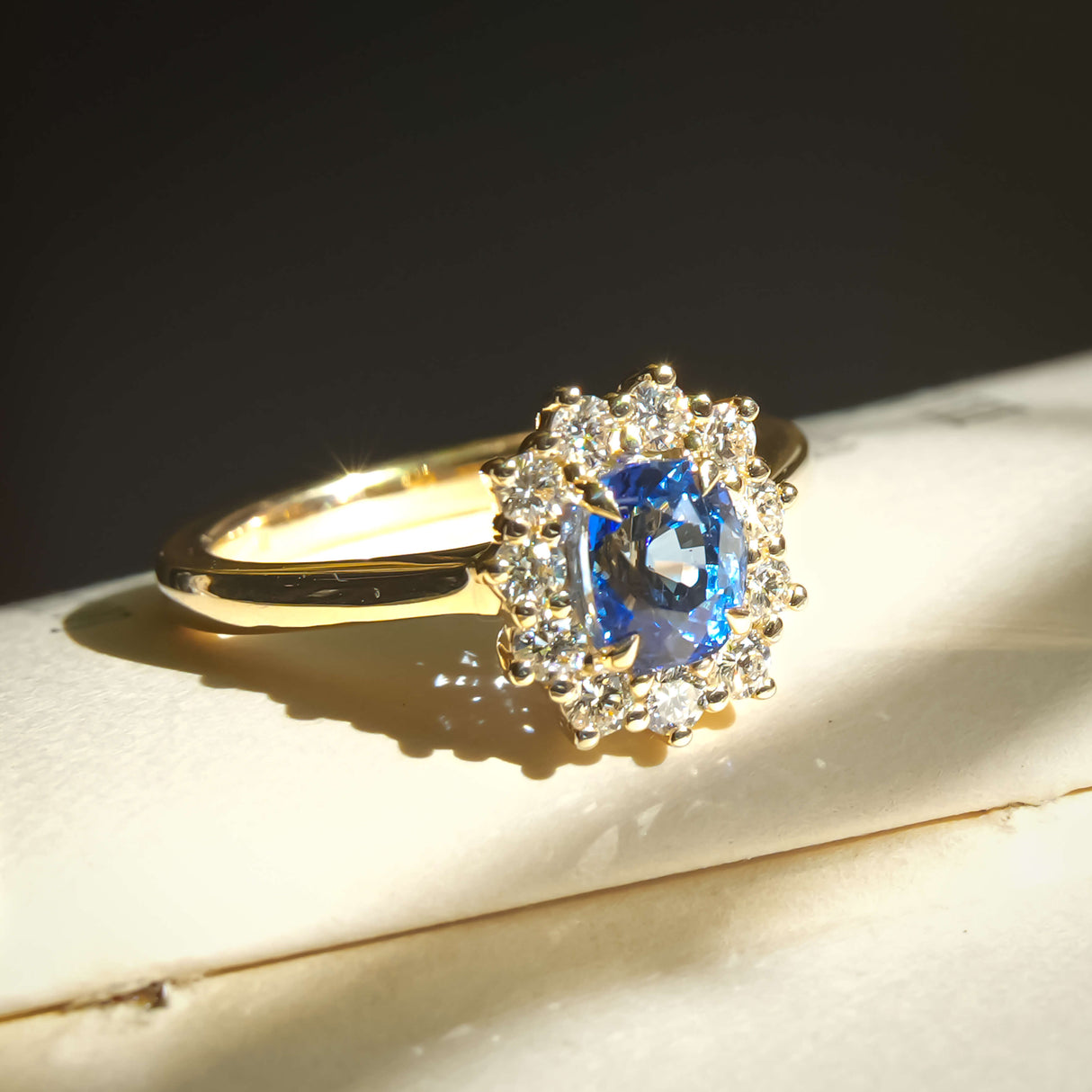Royal blue sapphire and diamond cluster engagement ring in classic yellow gold setting